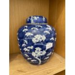A LARGE BLUE AND WHITE PRUNUS LIDDED GINGER JAR WITH ORIENTAL MARKINGS TO BASE