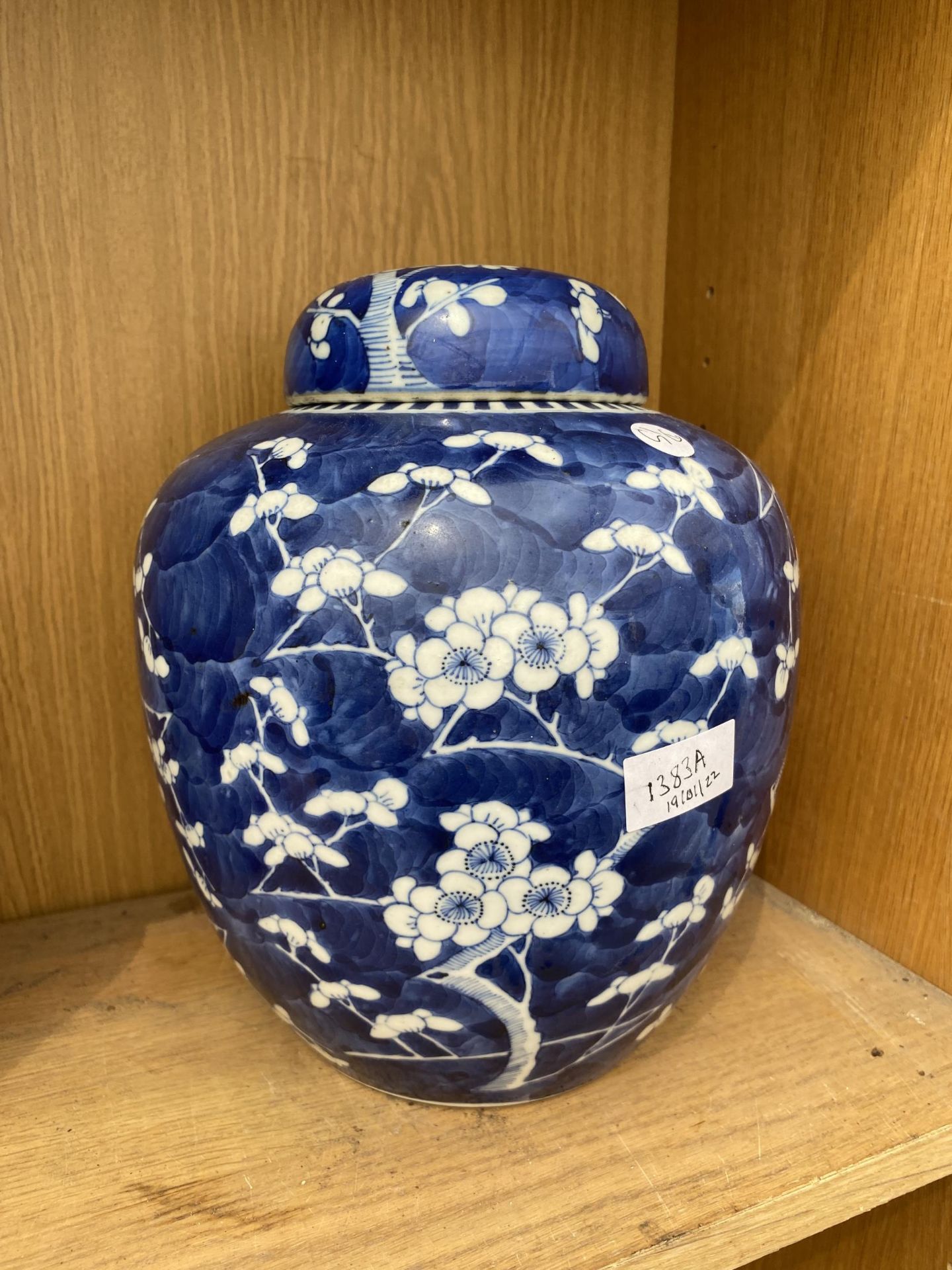 A LARGE BLUE AND WHITE PRUNUS LIDDED GINGER JAR WITH ORIENTAL MARKINGS TO BASE