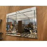 A DECORATIVE BEVELED EDGE WALL MIRROR (106CM X 76CM)