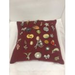 A CUSHION CONTAINING A QUANTITY OF COSTUME JEWELLERY BROOCHES