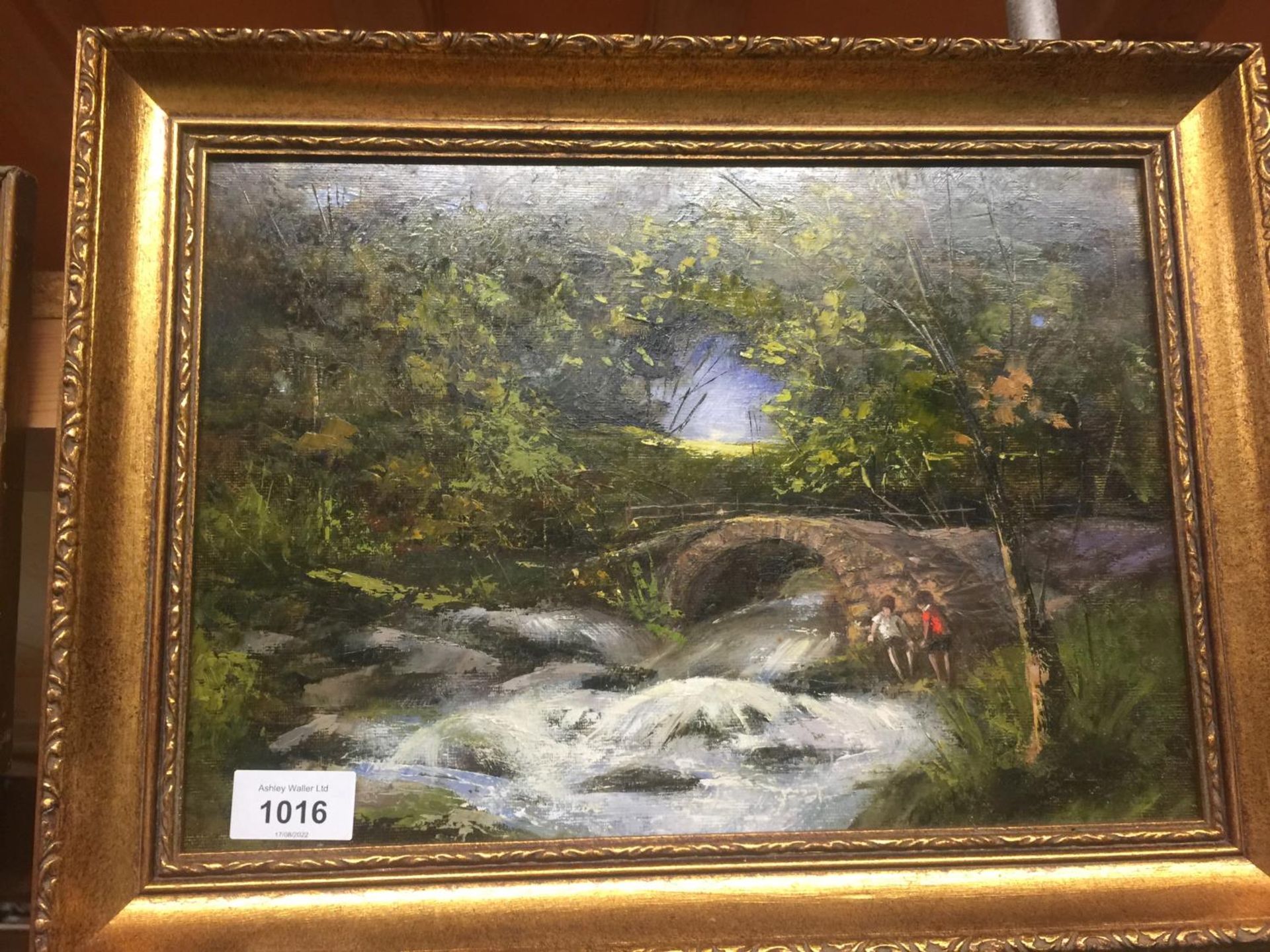 AN OIL ON BOARD OF A FLOWING STREAM, CHILDREN AND A BRIDGE 42CM X 32CM IN A GILT FRAME