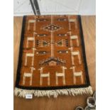 A SMALL HANDMADE PERUVIAN RUG WITH LLAMA PATTERN