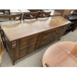 A REPRODUCTION OAK DRESSER BASE, 74" WIDE ENCLOSING TWO CUPBOARDS AND THREE DRAWERS