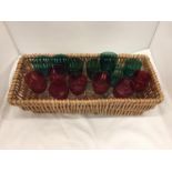 A WICKER BASKET CONTAINING FOURTEEN RED AND GREEN WINE GLASSES