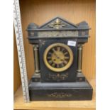 A DECORATIVE HEAVY SLATE MANTLE CLOCK WITH BRASS COLUMNS