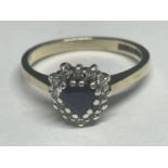 A 9 CARAT GOLD RING WITH A CENTRE SAPPHIRE AND DIAMONDS IN A HEAT SHAPE SIZE M