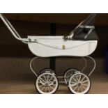 A VINTAGE DOLL'S CARRIAGE PRAM IN CREAM WITH BROWN UPHOLSTERY