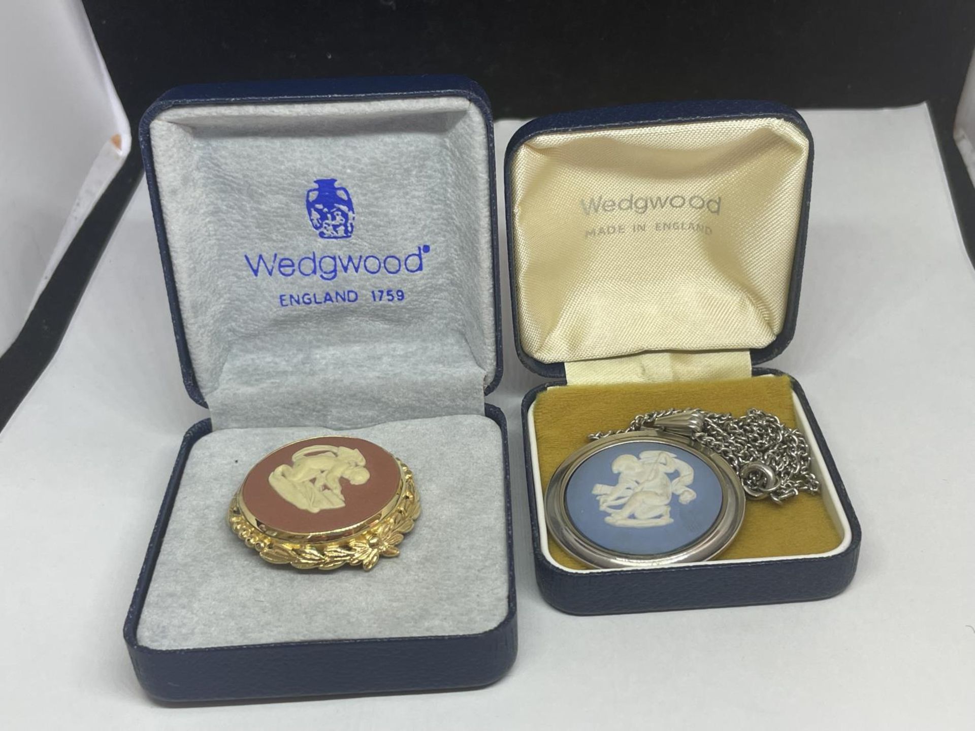 TWO BOXED WEDGWOOD JASPER WARE ITEMS TO INCLUDE A PINK BROOCH AND A BLUE PENDANT