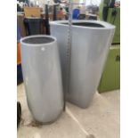 A GREY TRIANGULAR FIBRE GLASS PLANTER AND A FURTHER GREY FIBRE GLASS PLANTER