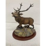 A FIGURE OF A STAG ON A WOODEN PLINTH