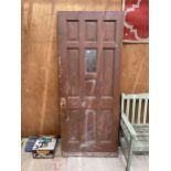 A WOODEN HOUSE DOOR WITH LEADED WINDOW AND NUMBERED 69