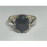 A 9 CARAT GOLD RING WITH A DARK RED STONE SIZE M/N