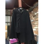 A VINTAGE POLICE CAPE AND TROUSERS. THE CAPE HAS A CHAIN FASTENING TO THE TOP WITH LIONS HEADS AND