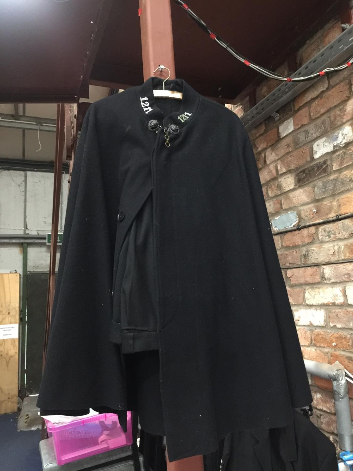 A VINTAGE POLICE CAPE AND TROUSERS. THE CAPE HAS A CHAIN FASTENING TO THE TOP WITH LIONS HEADS AND