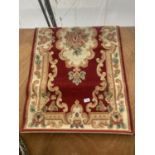 A SMALL RED PATTERNED RUG