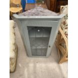 A MODERN PAINTED CORNER CUPBOARD WITH GLAZED AND LEADED DOOR