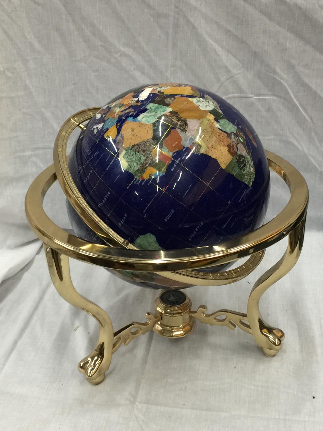 A GLOBE WITH MOTHER OF PEARL INLAYS ON BRASS ROTATING STAND H: 45CM