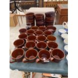 A LARGE QUANTITY OF BROWN CERAMIC WARE TO INCLUDE CUPS AND BOWLS ETC