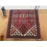 A LARGE RED PATTERNED FRINGED RUG