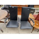 A PAIR OF BLACK FAUX LEATHER OPEN ARMCHAIRS ON POLISHED CHROME LEGS AND SUPPORTS