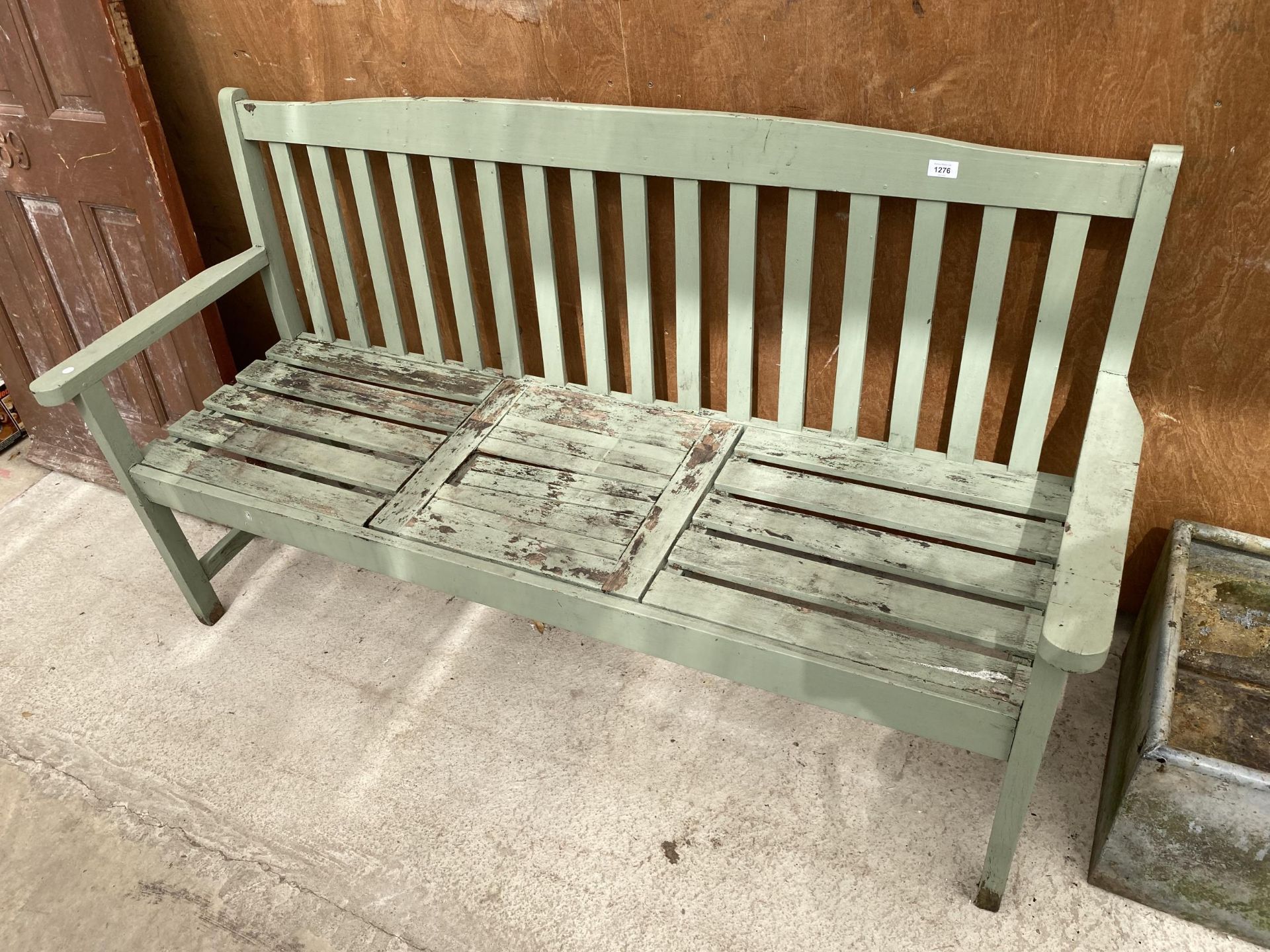 A WOODEN SLATTED GARDEN BENCH