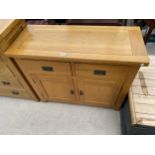 A MODERN OAK SIDEBOARD ENCLOSING TWO DRAWERS AND TWO CUBPOARDS, 41" WIDE