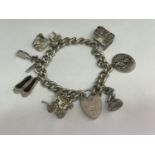 A SILVER CHARM BRACELET WITH EIGHT CHARMS