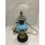 A CONVERTED VINTAGE BRASS OIL LAMP ON BRASS STAND AND SOLID HEAVY BASE WITH PAINTED CERAMIC