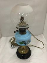 A CONVERTED VINTAGE BRASS OIL LAMP ON BRASS STAND AND SOLID HEAVY BASE WITH PAINTED CERAMIC