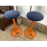 A PAIR OF VIVID ORANGE STOOLS WITH CAST METAL BASES AND COLUMNS, WITH BLUE SEATS, 16" DIAMETER EACH