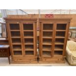 A PAIR OF PINE TWO DOOR CABINETS WITH WIREWORK DOORS AND DRAWER TO THE BASE, 43" WIDE EACH