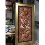 THREE PRINTS, TWO FRAMED, TO INCLUDE A VILLAGE SCENE AND A FRAMED TEXTILE DEPICTING FANTASY BIRDS