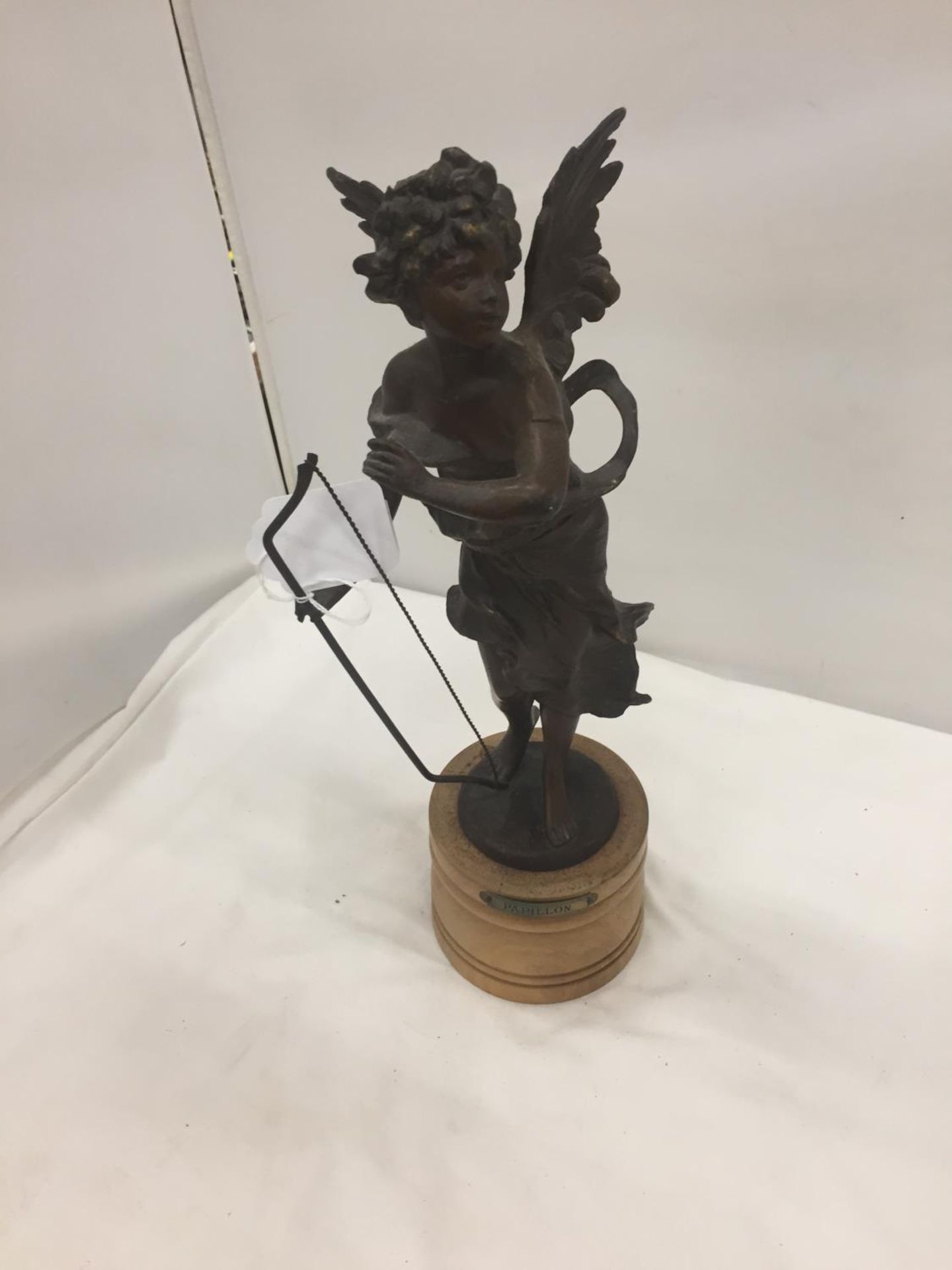 A METAL CHERUBIC CUPID STYLE FIGURE ON A WOODEN BASE HEIGHT 40CM