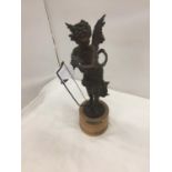 A METAL CHERUBIC CUPID STYLE FIGURE ON A WOODEN BASE HEIGHT 40CM