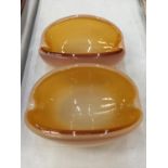 A PAIR OF OVAL SHAPED GLASS BOWLS WITH AN AMBER INTERIOR AND AN OPAQUE EXTERIOR