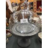 A METAL BASED CAKE STAND WITH A GLASS DOMED TOP
