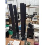 AN LG SURROUND SOUND SYSTEM WITH SUB WOOFER, SOUND BAR AND FOUR TOWER SPEAKERS