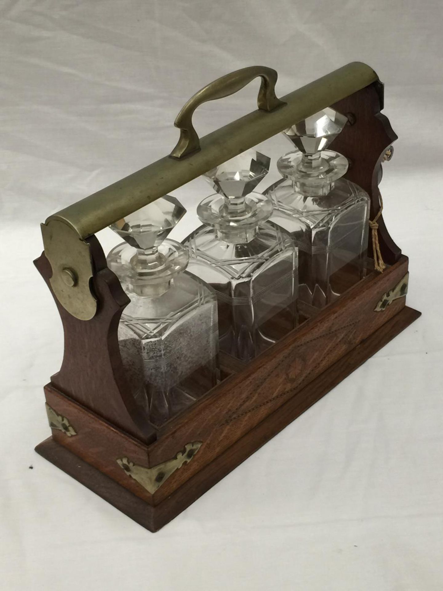 A VINTAGE MAHOGANY AND BRASS TANTALUS WITH THREE MATCHING DECANTERS AND KEY - Image 10 of 16