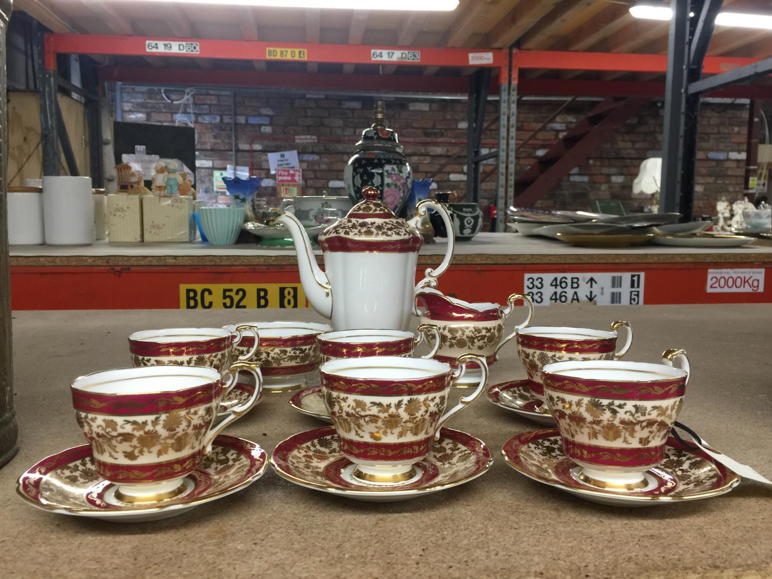 A PARAGON CHINA COFFEE SET IN A CRIMSON AND GILT PATTERN TO INCLUDE A COFFEE POT, CREAM JUG, SUGAR