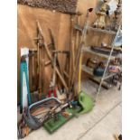 A LARGE ASSORTMENT OF GARDEN TOOLS TO INCLUDE A SYTHE, SPADES, FORKS AND BOW SAWS ETC
