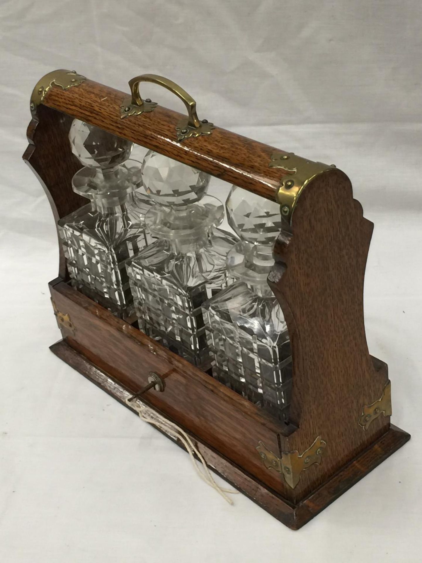 A VINTAGE MAHOGANY TANTALUS DECANTER SET WITH BRASS DETAILING AND A KEY - Image 2 of 9