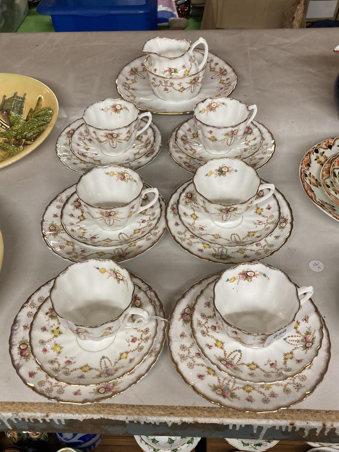 A 'MICHAEL' CHINA TEASET WITH FLORAL SWAG DESIGN TO INCLUDE CAKE PLATE CREAM JUG, SUGAR BOWL,