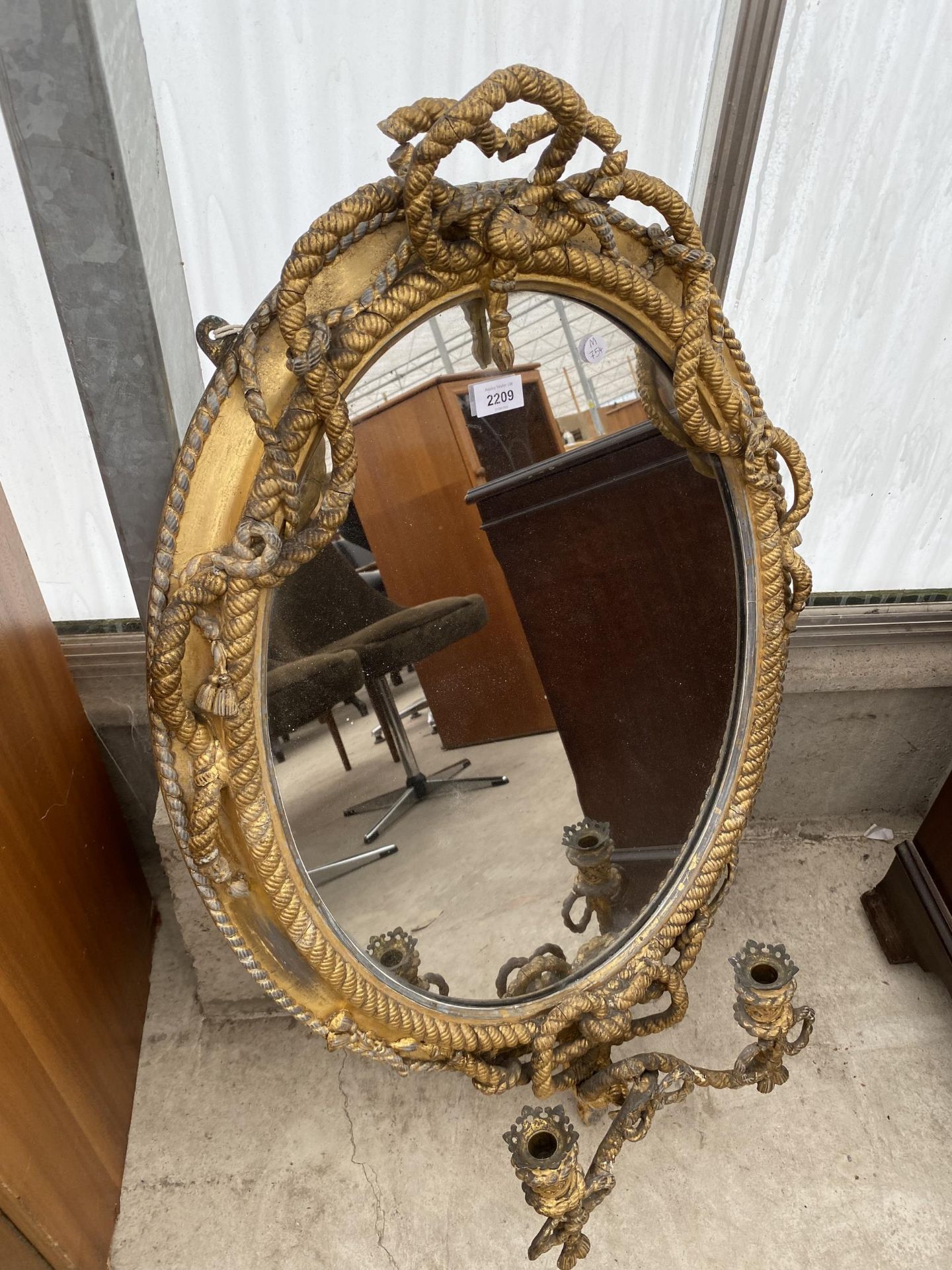 AN ELABORATE VICTORIAN GILT FRAMED MIRROR WITH ROPE DESIGN AND LOWER CANDLE HOLDERS