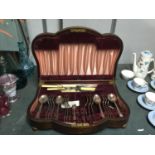 A MAHOGANY CASED SERPENTINE FRONT VINTAGE CANTEEN OF CUTLERY WITH FITTED INTERIOR