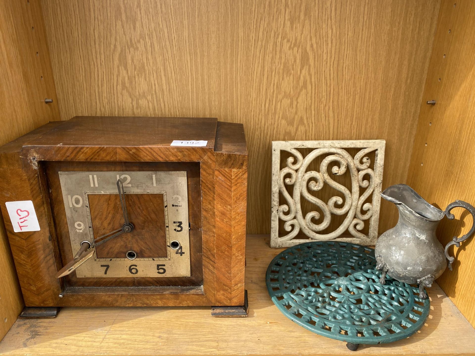 A WOODEN MANTLE CLOCK, TWO TRIVET STANDS AND A JUG