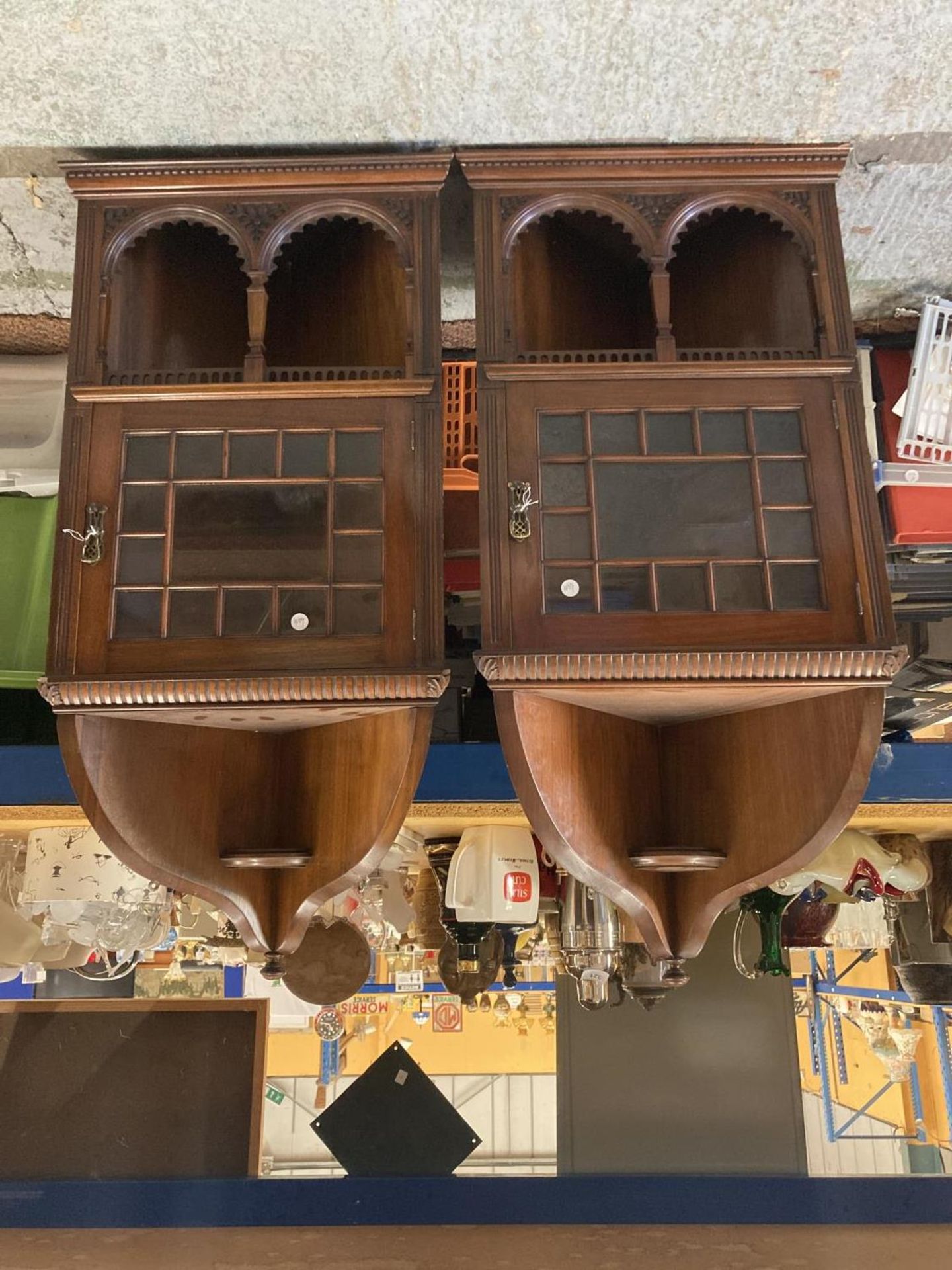 A PAIR OF EDWARDIAN MAHOGANY ASTRAGAL GLAZED CORNER CABINETS WITH CARVED ARCHED TOPS AND LOCKING