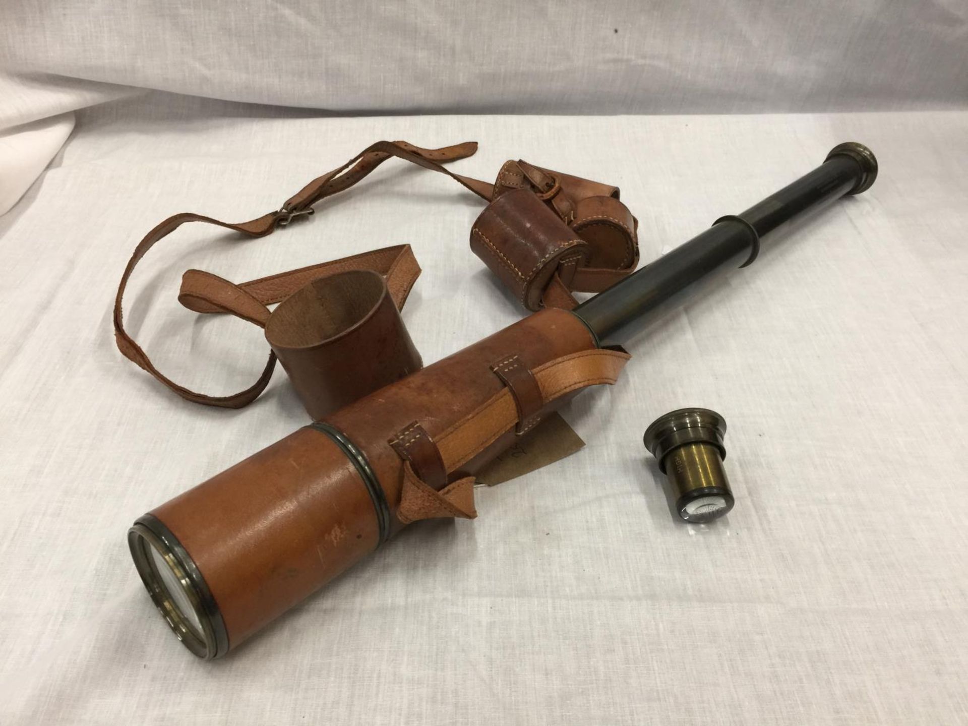 A VINTAGE BRASS AND LEATHER TELESCOPE RECONDITIONED FOR JOHN BARKER & CO LTD KENSINGTON W.8. BY