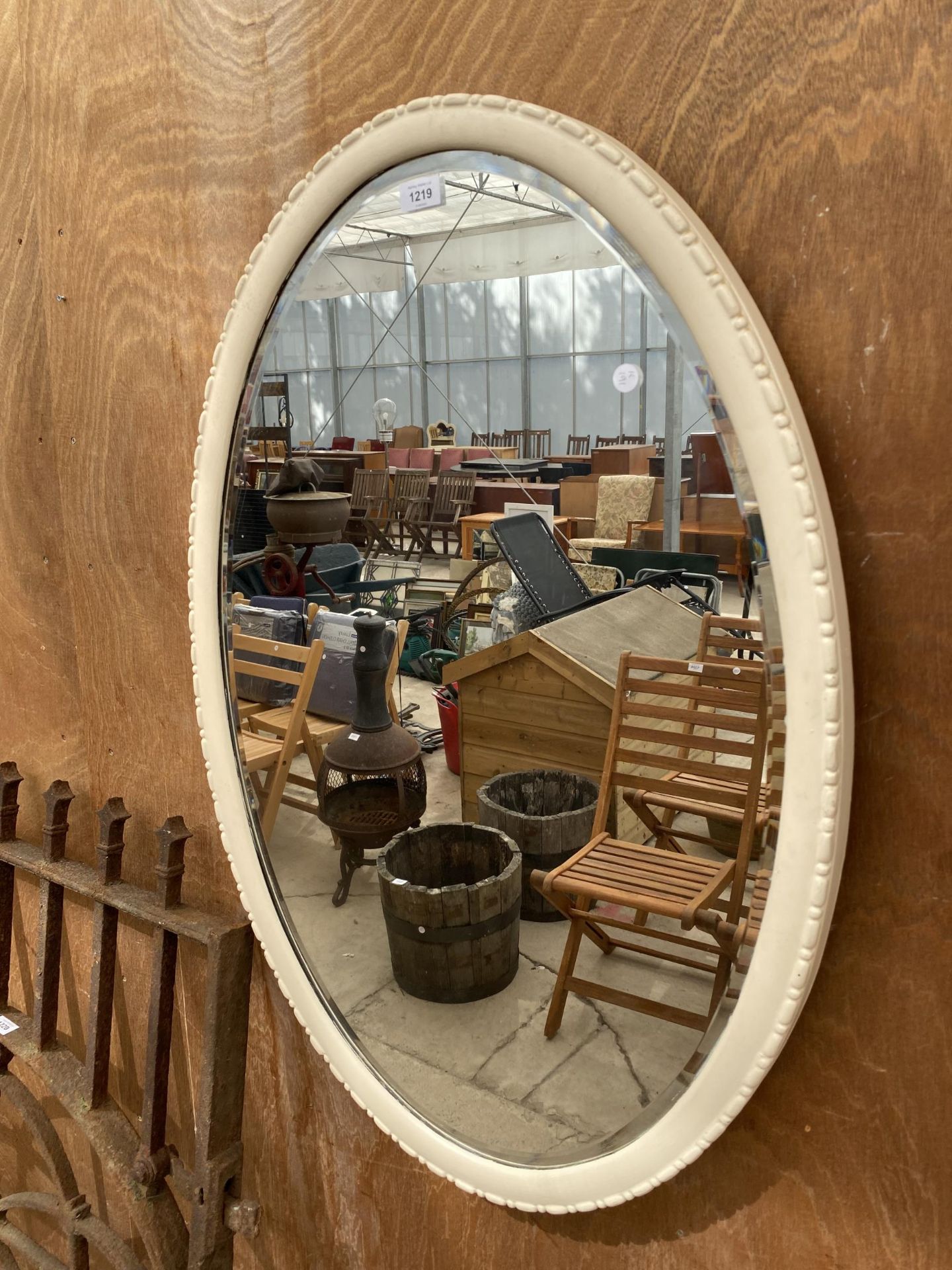 A DECORATIVE WOODEN FRAMED BEVELED EDGE WALL MIRROR