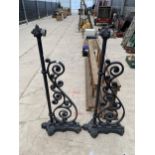 A PAIR OF DECORATIVE CAST IRON OUTDOOR WALL LIGHT BRACKETS WITH ORNATE CAST ALLOY DETAIL