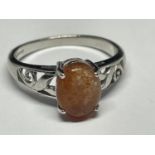 A 9 CARAT WHITE GOLD RING WITH AN ORANGE CABOCHON STONE SIZE N/O